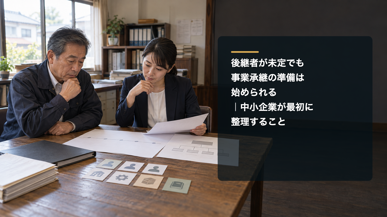 事業承継の工程表と組織図を確認する中小企業経営者と女性担当者、右側の記事タイトル